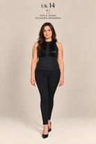 A woman modeling a black sleeveless top and matching black leggings against a plain beige studio background. Text at the top reads 'UK 14 (L) APPLE SHAPE ROUNDER ABDOMEN'.
